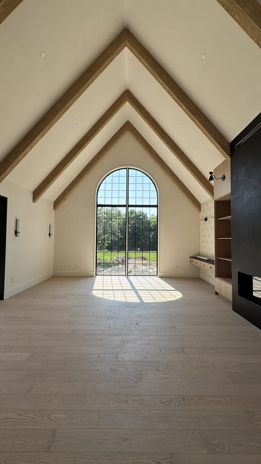Belsite great room with vaulted timber ceiling and arched cathedral window