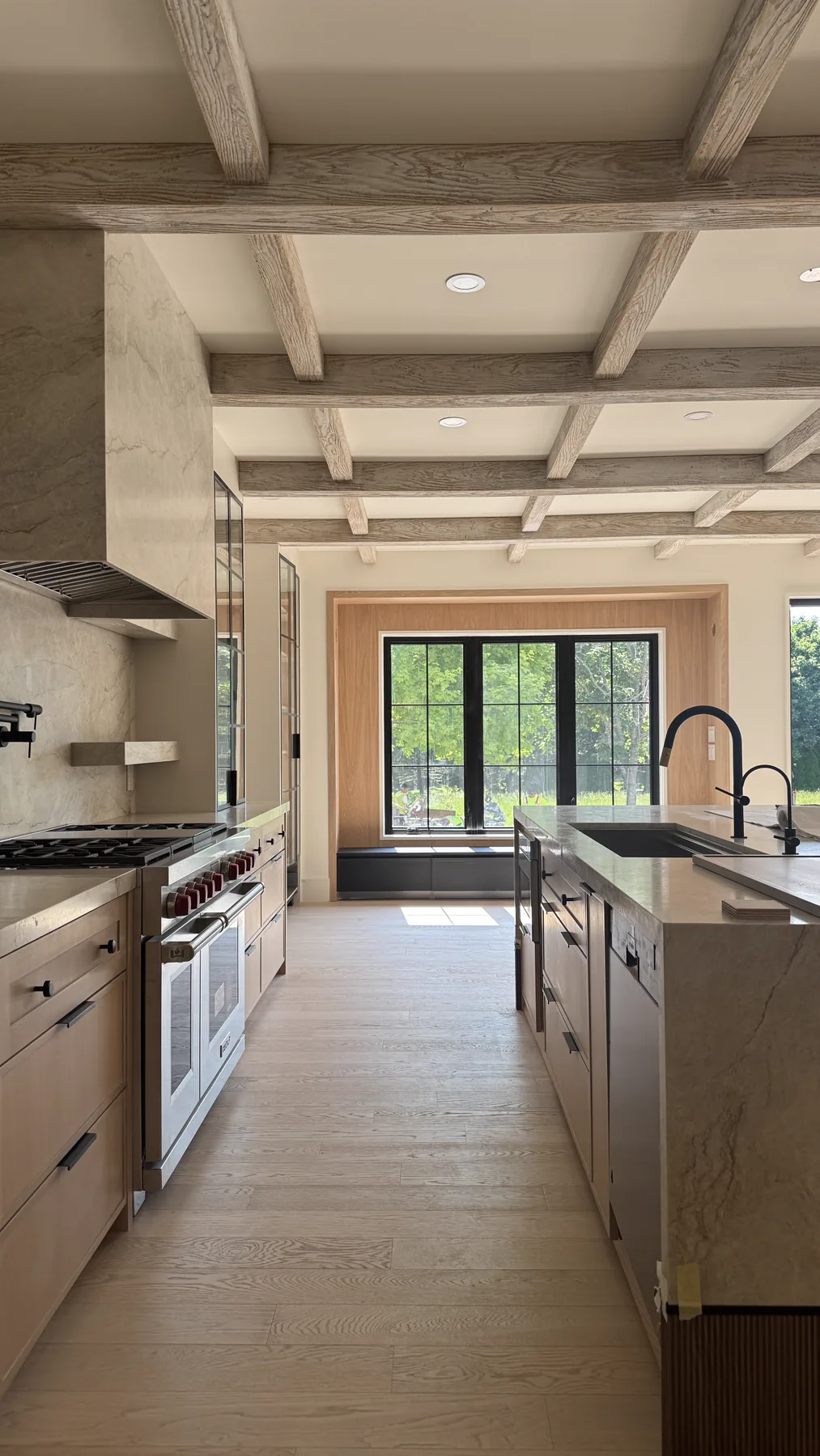 Belsite gourmet kitchen with coffered wood beam ceiling and marble island